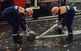 Ein gebrauchter B-Schlauch wird zu zweit gewickelt